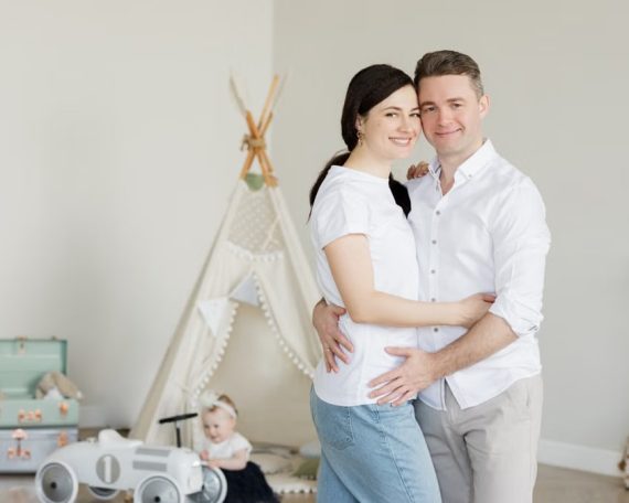 A joyful family with a toddler in a cozy room with playful decor and a teepee.