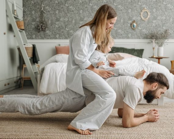 A joyful family enjoys playful bonding in a cozy bedroom, enhancing love and togetherness.